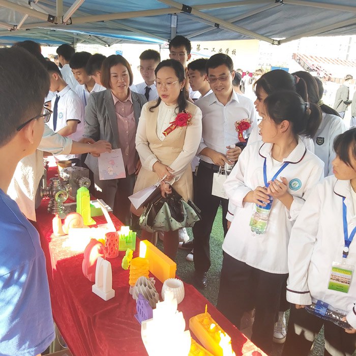 1606036908175552.jpg 嘉宾和同学对3D打印产品产生浓厚兴趣.jpg